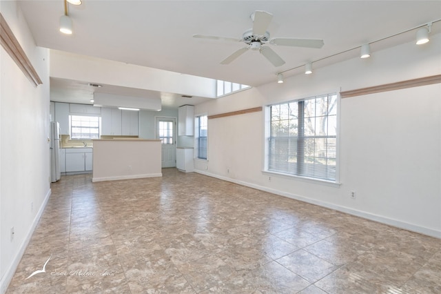 unfurnished living room with ceiling fan