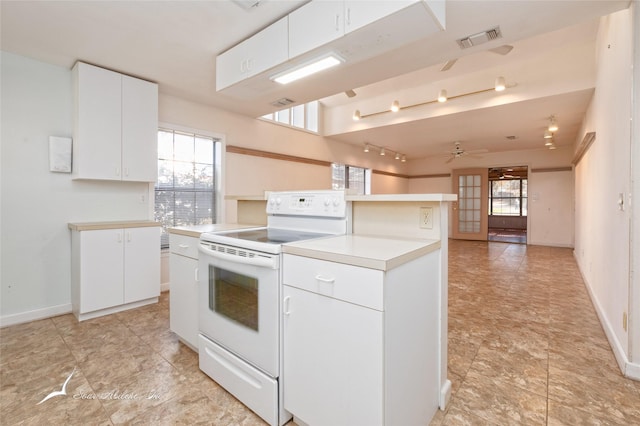 kitchen featuring white cabinets, ceiling fan, a center island, and electric stove