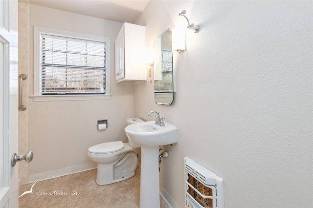 bathroom with tile patterned floors, toilet, sink, and heating unit