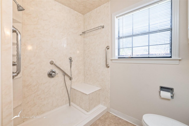 bathroom featuring tile patterned floors, toilet, and a tile shower