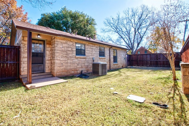 rear view of house with a lawn and central air condition unit