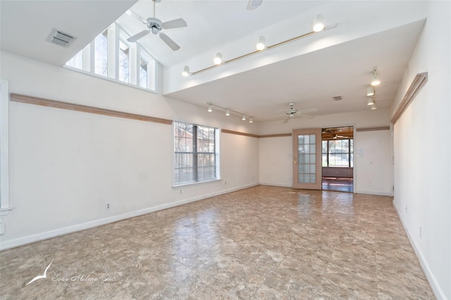 spare room featuring ceiling fan, plenty of natural light, and a high ceiling