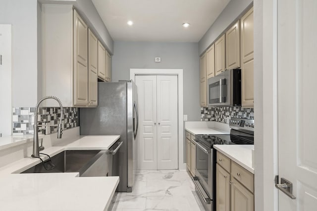 kitchen featuring stainless steel appliances, sink, backsplash, and cream cabinetry