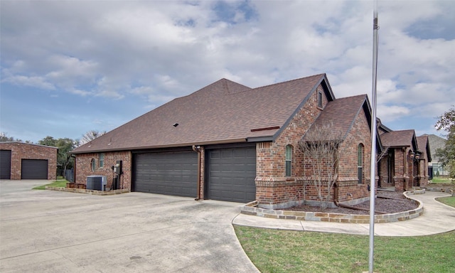 view of side of property with a garage and cooling unit