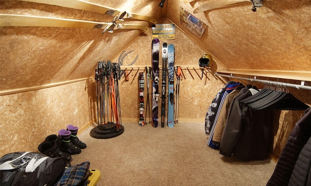 walk in closet with carpet floors and lofted ceiling