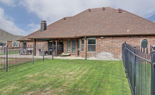 rear view of property with a lawn and a patio