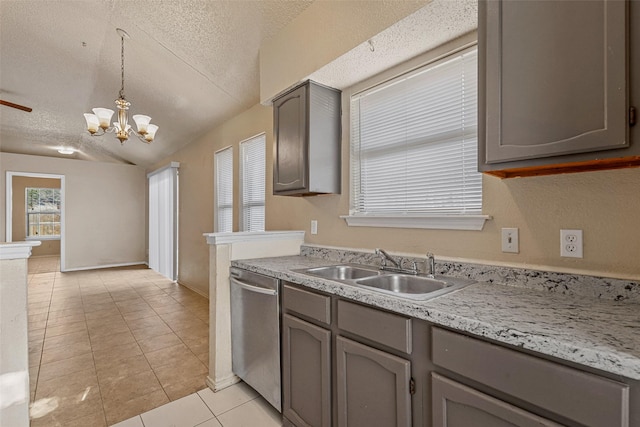 kitchen with a textured ceiling, stainless steel dishwasher, hanging light fixtures, and sink