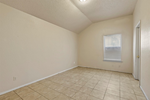 interior space with a textured ceiling, light tile patterned floors, and vaulted ceiling