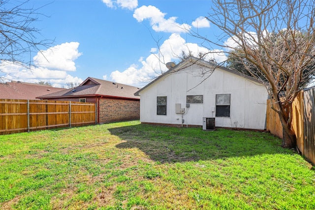 back of property featuring a lawn and central AC