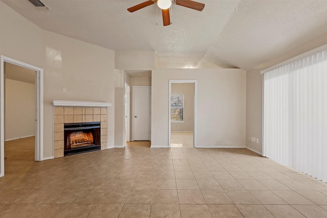 unfurnished living room with a fireplace, light tile patterned floors, a textured ceiling, and ceiling fan