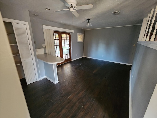 unfurnished living room with dark hardwood / wood-style flooring, ceiling fan, french doors, and a textured ceiling