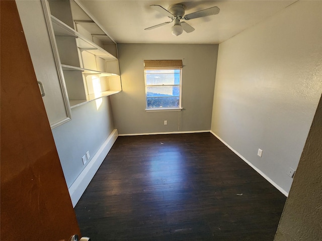 empty room featuring ceiling fan and dark hardwood / wood-style flooring