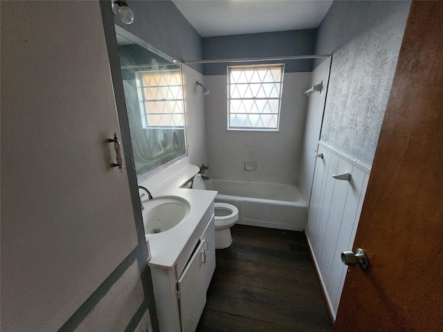 full bathroom featuring hardwood / wood-style floors, vanity, toilet, and tub / shower combination