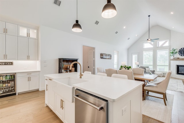 kitchen featuring white cabinets, wine cooler, stainless steel dishwasher, and hanging light fixtures