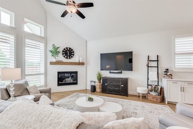 living room with a brick fireplace, vaulted ceiling, light hardwood / wood-style flooring, and ceiling fan