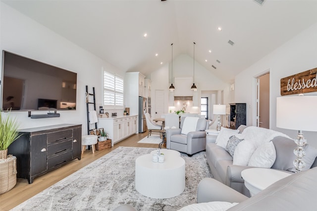 living room featuring light hardwood / wood-style flooring and high vaulted ceiling