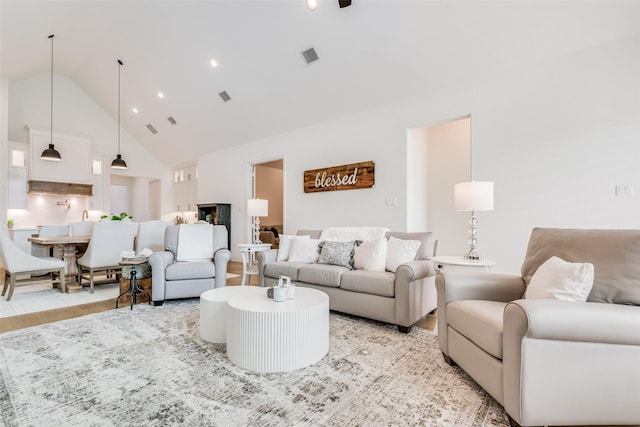 living room featuring light hardwood / wood-style floors and high vaulted ceiling