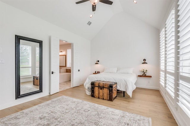 bedroom featuring connected bathroom, light hardwood / wood-style floors, vaulted ceiling, and ceiling fan