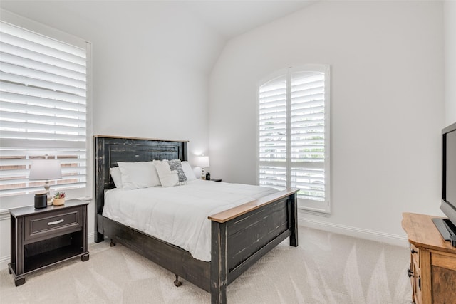 bedroom featuring light colored carpet and lofted ceiling