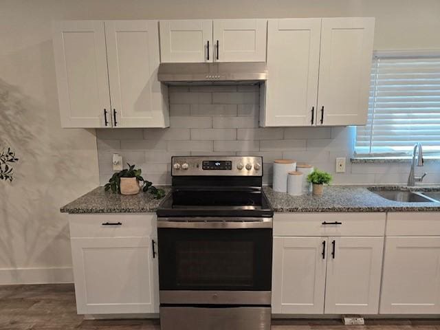 kitchen with white cabinets, sink, stainless steel range with electric cooktop, and dark stone counters