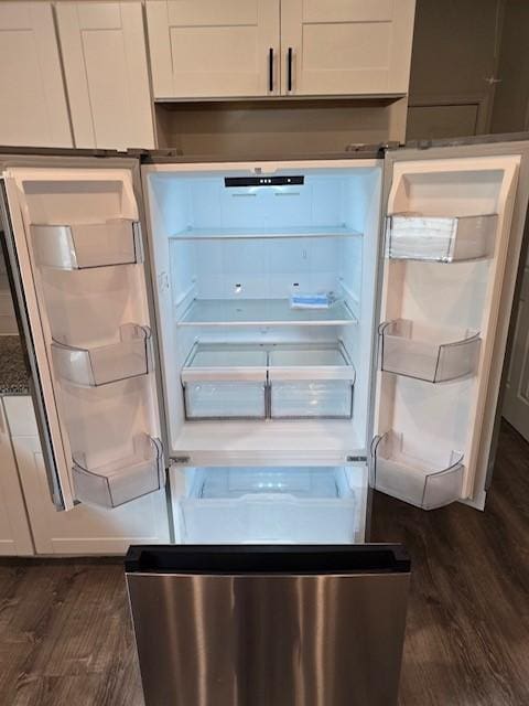 details with refrigerator, white cabinets, and dark hardwood / wood-style flooring