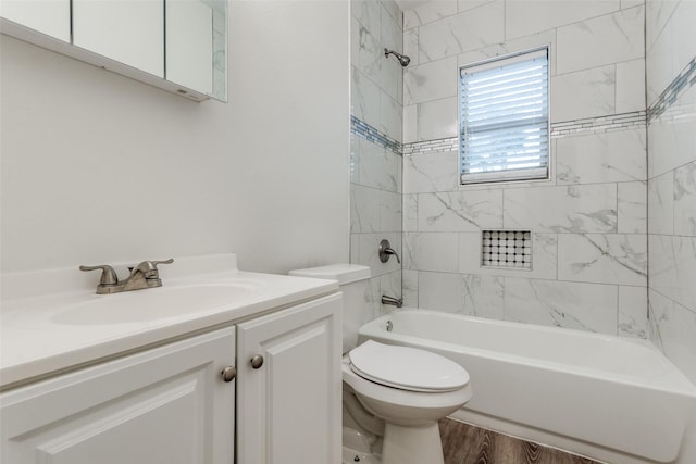 full bathroom featuring hardwood / wood-style floors, vanity, tiled shower / bath combo, and toilet