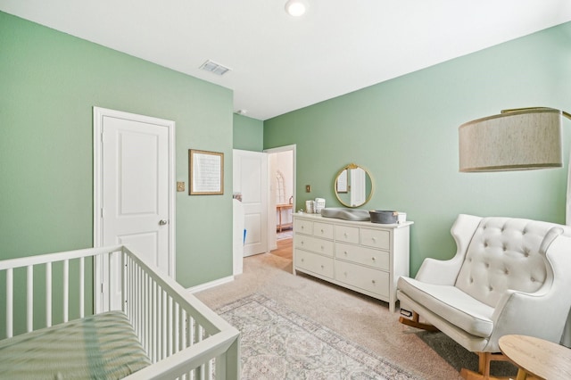 bedroom featuring a nursery area, baseboards, visible vents, and carpet floors