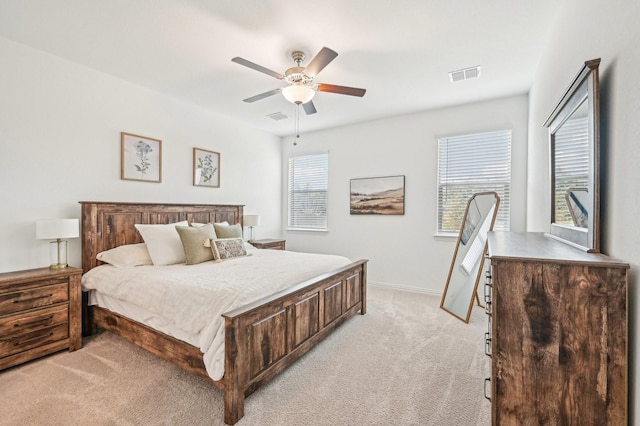 bedroom with light carpet, visible vents, a ceiling fan, and baseboards