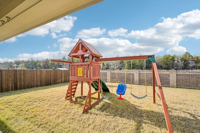 view of playground featuring a lawn and a fenced backyard