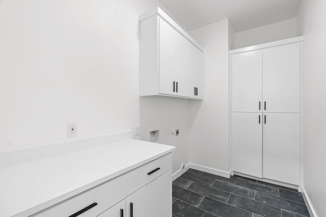 laundry area with electric dryer hookup and cabinets