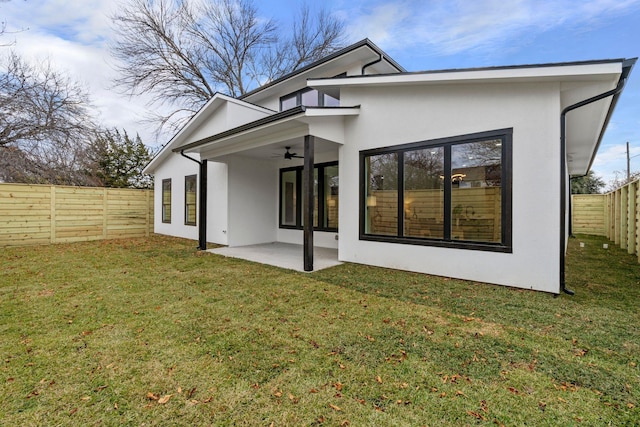 rear view of property featuring a lawn, ceiling fan, and a patio