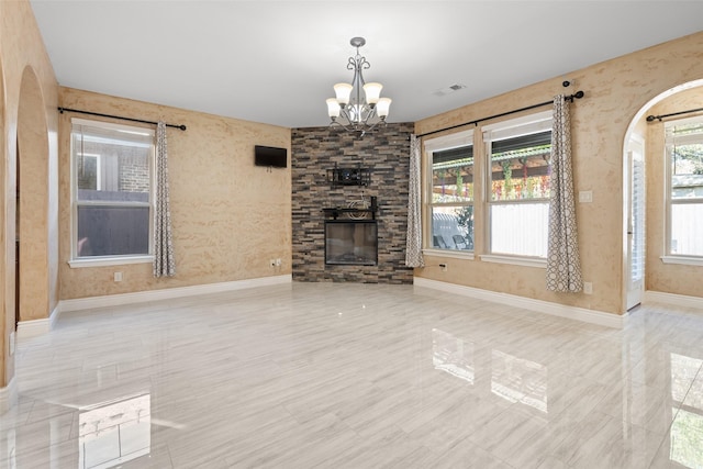 unfurnished living room with a fireplace and an inviting chandelier