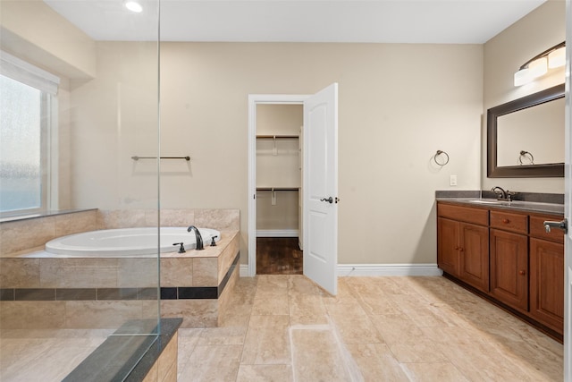 bathroom featuring vanity and tiled bath