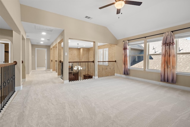 carpeted spare room with ceiling fan, a healthy amount of sunlight, and vaulted ceiling