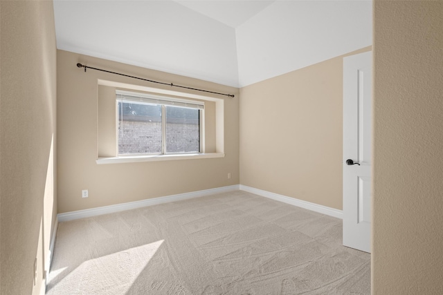 unfurnished room featuring lofted ceiling and light carpet