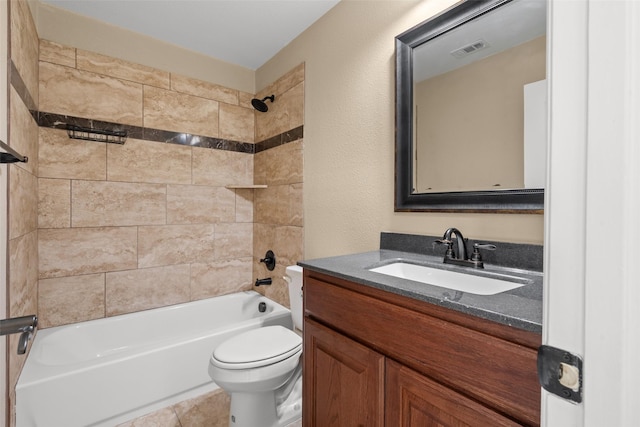 full bathroom with vanity, tiled shower / bath combo, and toilet