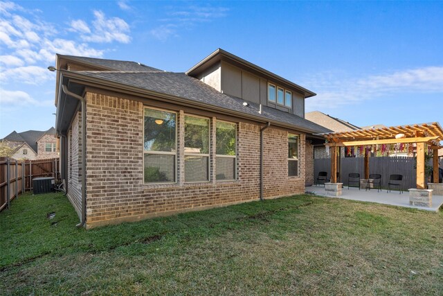 rear view of property with a pergola, a patio area, a yard, and central AC unit