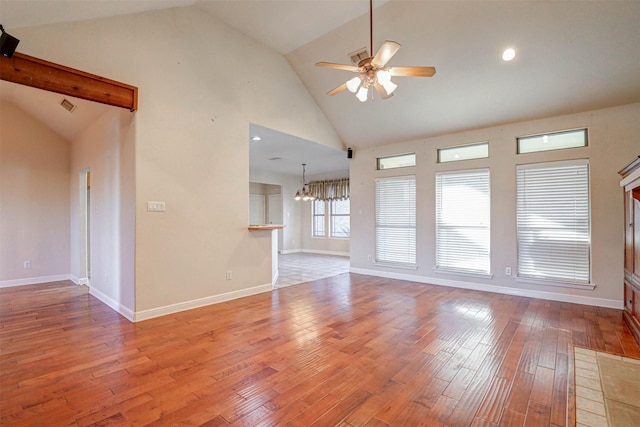 interior space featuring ceiling fan with notable chandelier, high vaulted ceiling, and light hardwood / wood-style flooring