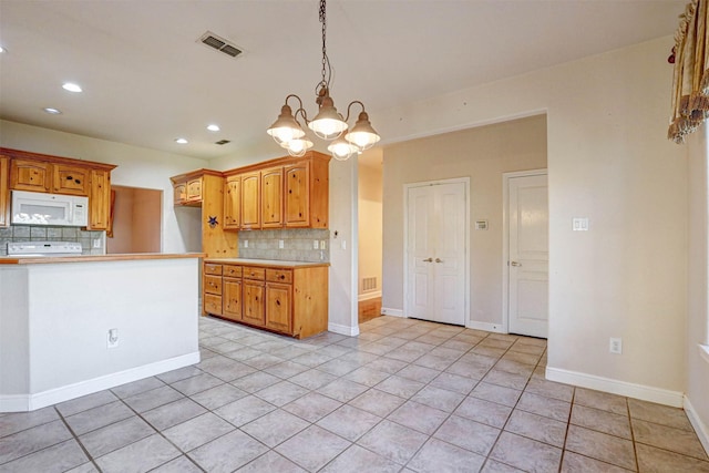 kitchen with stove, pendant lighting, backsplash, and light tile patterned floors