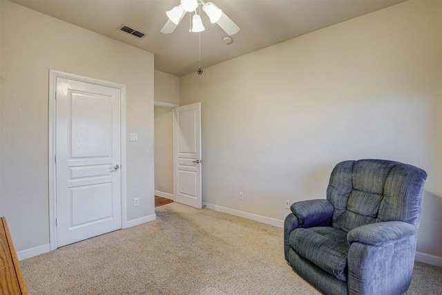 living area featuring light carpet and ceiling fan