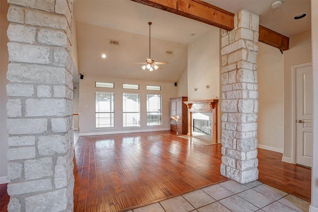 unfurnished living room featuring light wood-type flooring, decorative columns, ceiling fan, high vaulted ceiling, and a fireplace