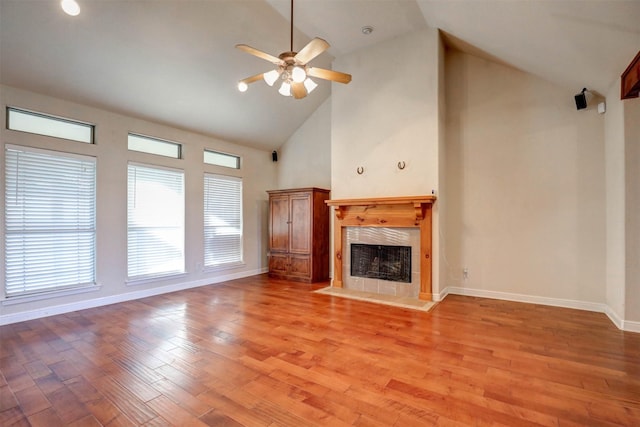 unfurnished living room featuring ceiling fan, a fireplace, high vaulted ceiling, and light hardwood / wood-style floors