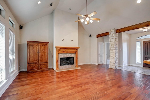 unfurnished living room with plenty of natural light, ceiling fan, light hardwood / wood-style floors, and a tile fireplace