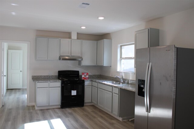 kitchen featuring gray cabinetry, sink, stainless steel refrigerator with ice dispenser, black range with gas cooktop, and light hardwood / wood-style floors