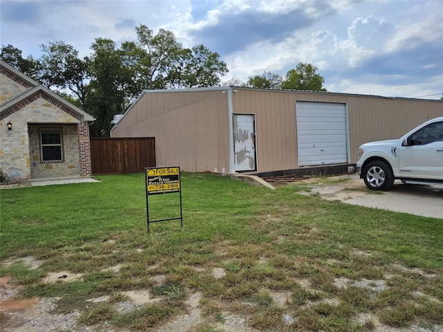 view of outbuilding featuring a lawn and a garage