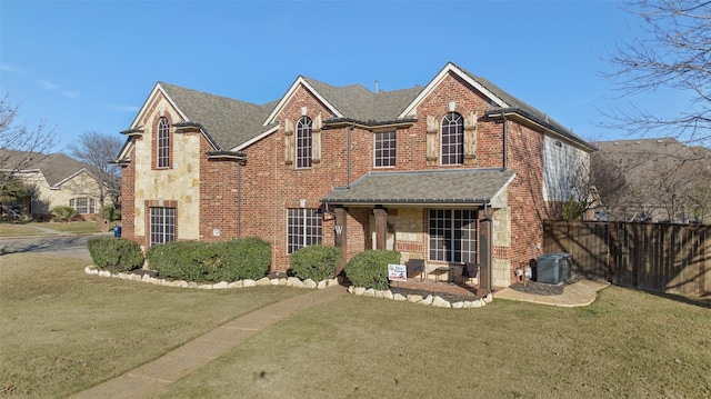 front of property featuring central air condition unit and a front yard