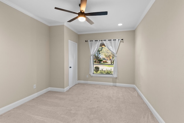 carpeted spare room featuring ceiling fan and crown molding