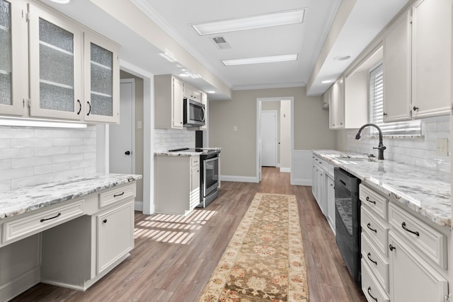 kitchen with decorative backsplash, white cabinets, stainless steel appliances, and light stone counters