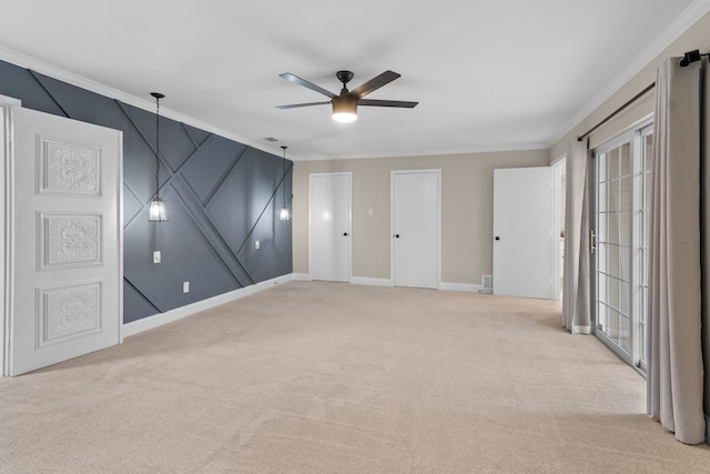 carpeted empty room with ceiling fan and crown molding