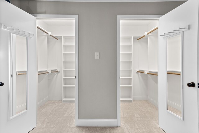 walk in closet with light carpet